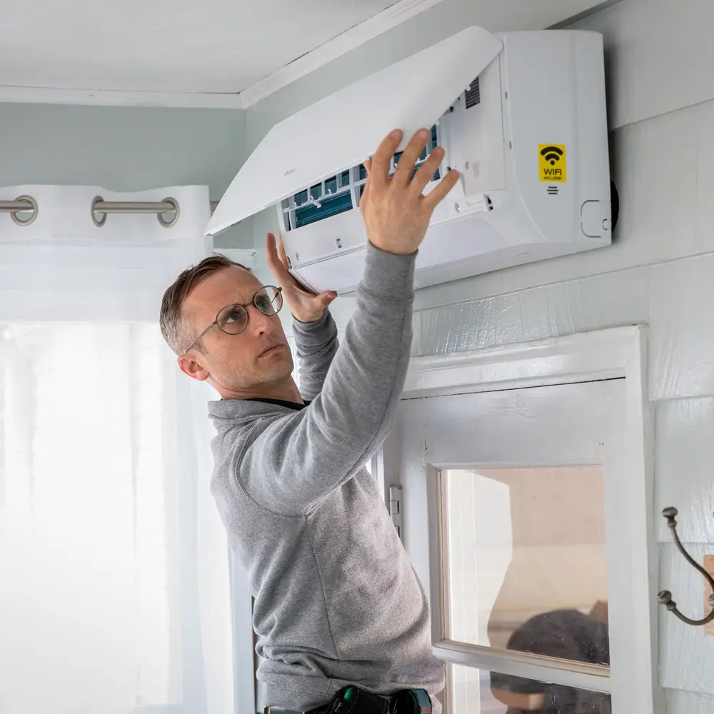 HVAC installer checking refrigerant lines and airflow during new system setup