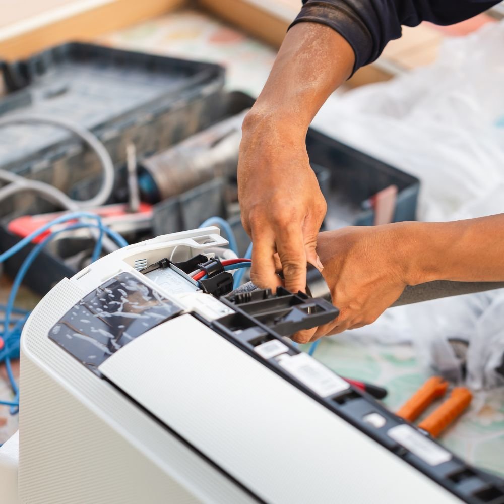 Technician cleaning outdoor AC unit before peak summer cooling season