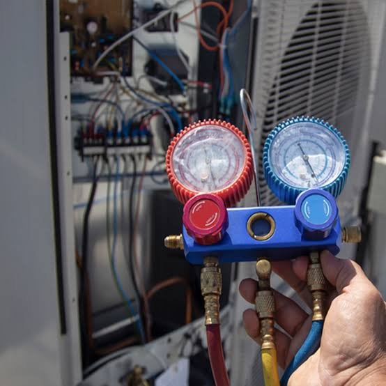 Experienced HVAC technician inspecting AC components and airflow with testing tools