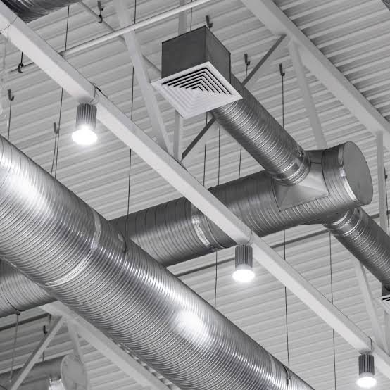HVAC technician diagnosing airflow restrictions inside exposed residential duct system